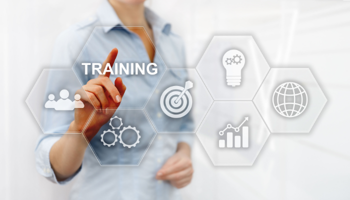 A woman pointing towards 7 hexagons with various icons and the word training inside them.